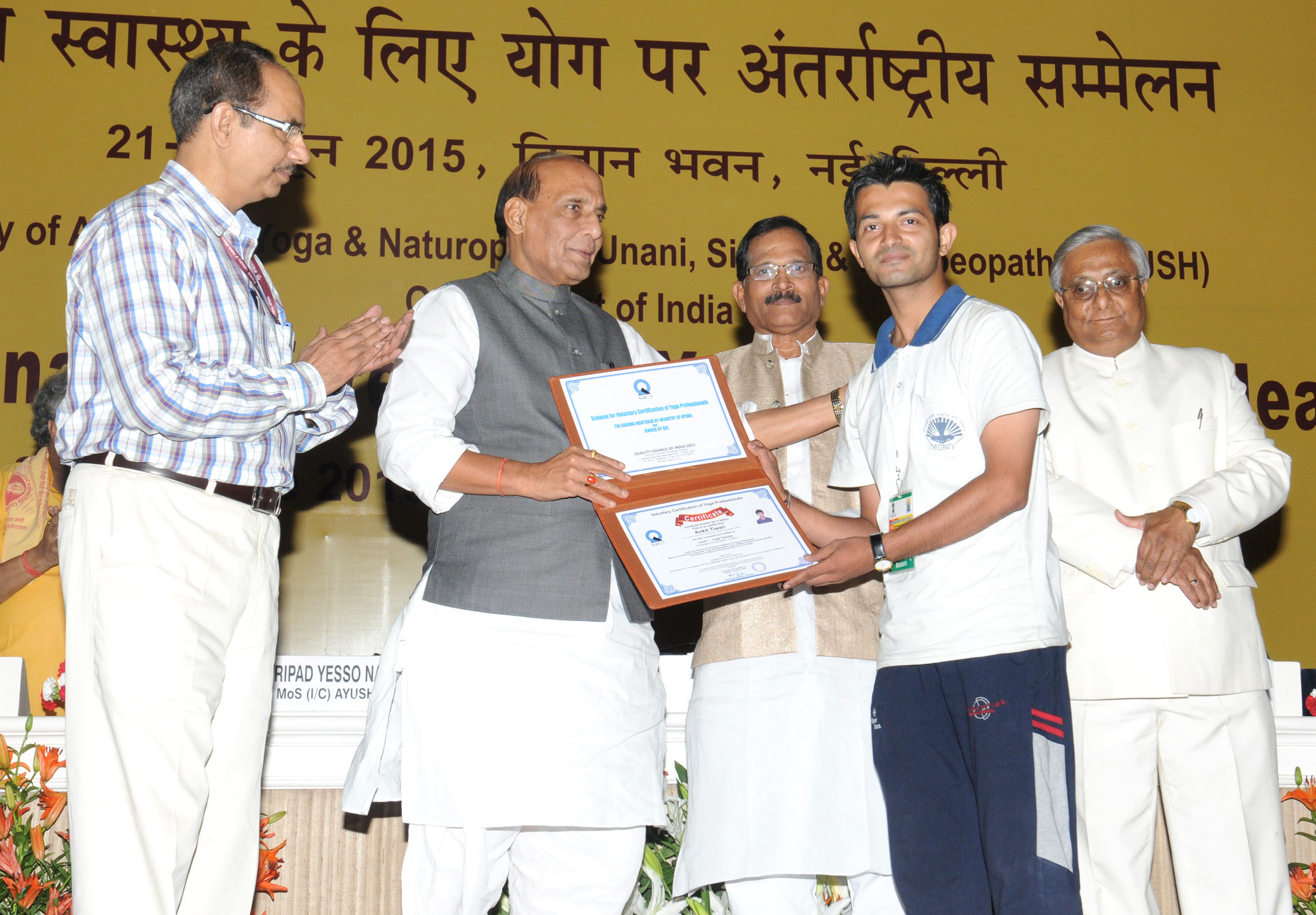 The Union Home Minister, Shri Rajnath Singh presenting the Voluntary Certification of Yoga Professionals, at the International Conference on Yoga for Holistic Health, in New Delhi on June 22, 2015. 	The Minister of State for AYUSH (Independent Charge) and Health & Family Welfare, Shri Shripad Yesso Naik and the Secretary, Ministry of AYUSH, Shri Nilanjan Sanyal are also seen.