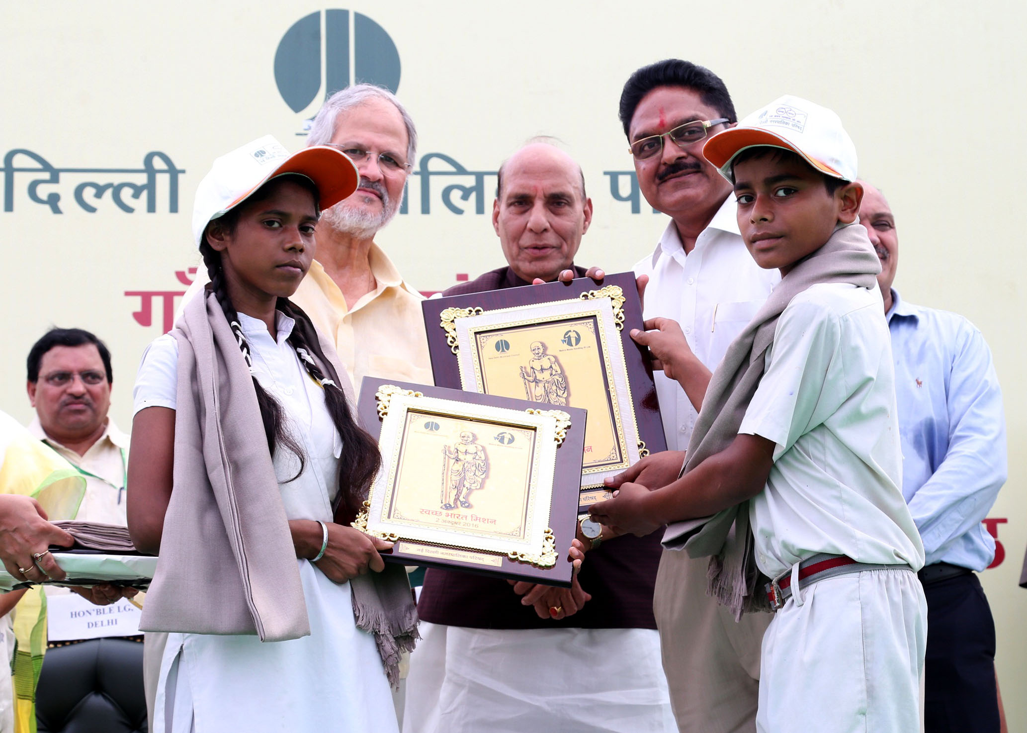 The Union Home Minister, Shri Rajnath Singh felicitating children who made contribution towards the 'Cleanliness Drive' at the 'Swachhta Rally", in New Delhi on October 02, 2016. 	The Lt. Governor of Delhi, Shri Najeeb Jung is also seen.