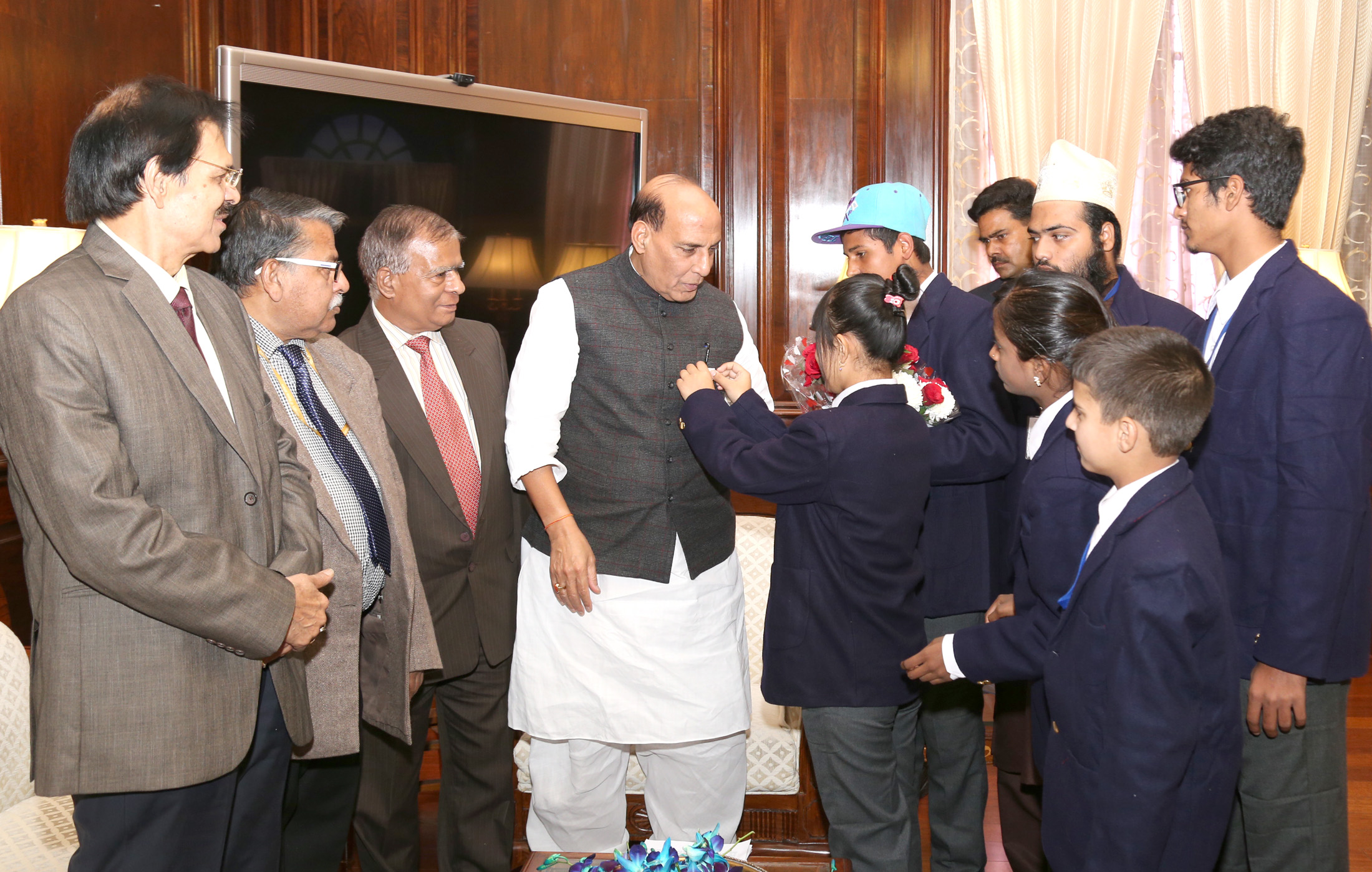 A group of children pinning Flag on the Union Home Minister, Shri Rajnath Singh, as part of the Communal Harmony Campaign Week, in New Delhi on November 24, 2016.